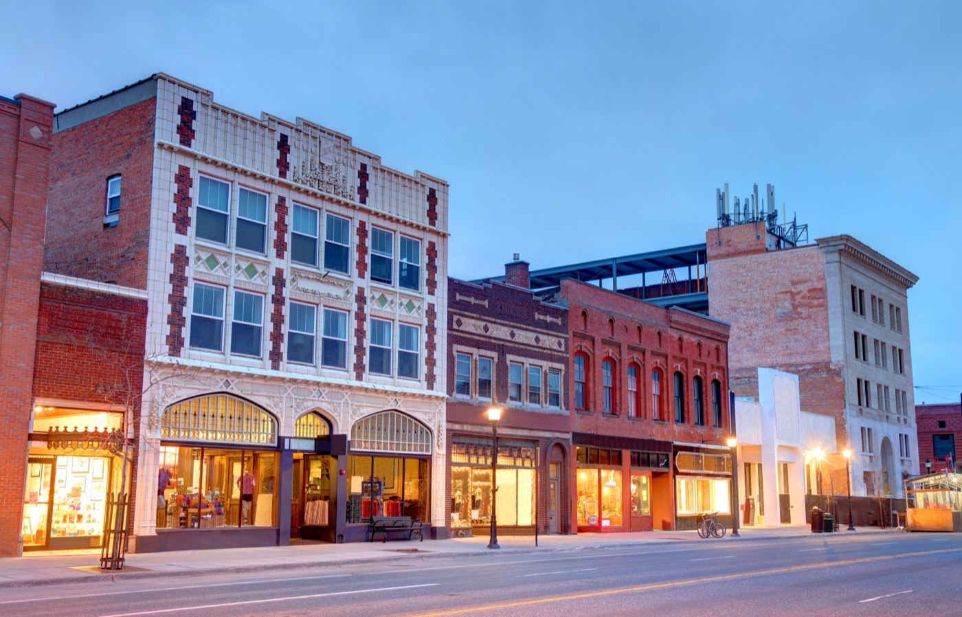 Historic brick storefronts on a downtown Bozeman street at dusk.