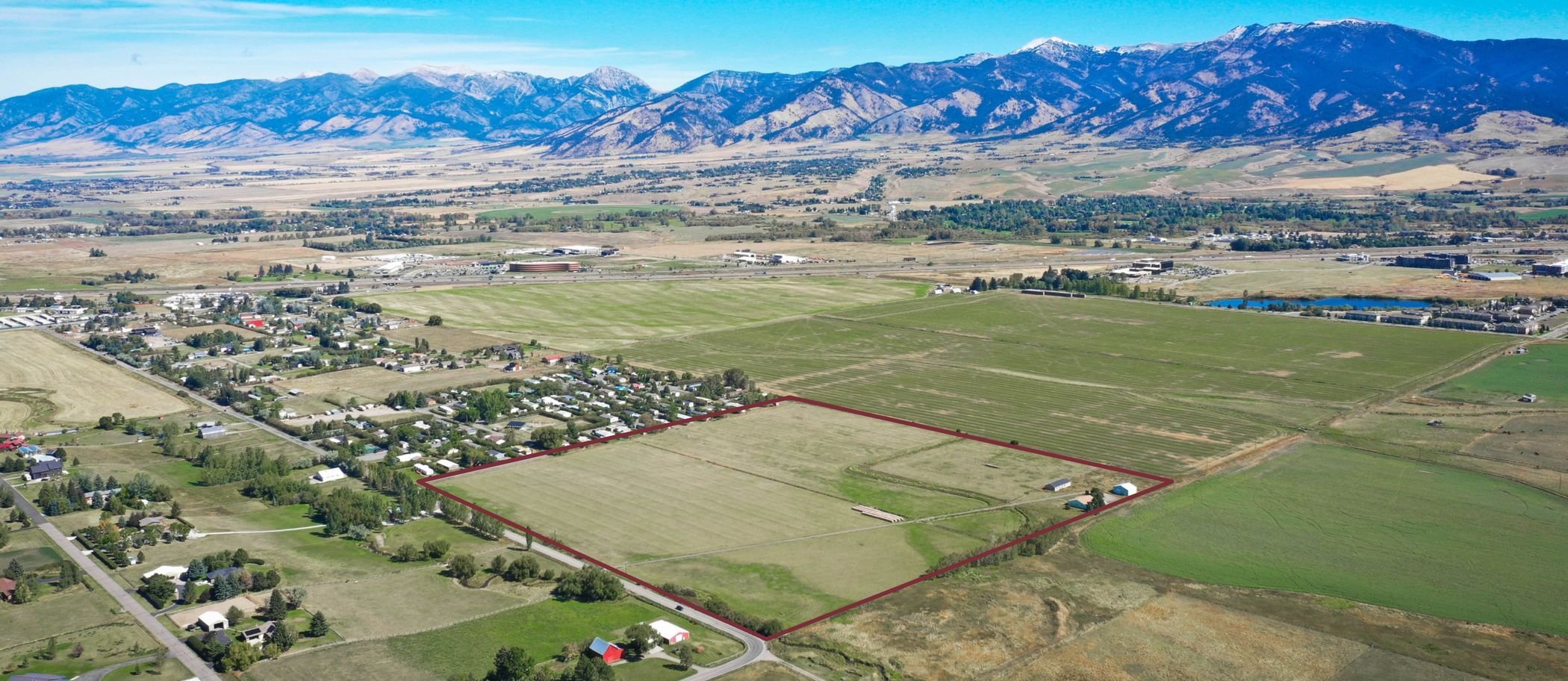 Aerial view of the 40-acre Hidden Valley Road property outlined in red, with the Bridger Range behind.